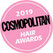 Ein rosafarbenes rundes Abzeichen mit der Aufschrift „2019 Cosmopolitan Hair Awards“ in fettem weißen und schwarzen Text.