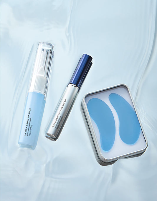 Drei Pflegeprodukte der RevitaLash® Cosmetics Brow Refresh Collection, darunter RevitaBrow Advanced Spring 2025 auf Wasseroberfläche: Lash & Brow Masque, RevitaBrow-Serum und blaue Augenpads in Metallbox.