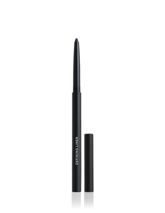 Der schwarze Defining Liner Eyeliner von RevitaLash® Cosmetics steht aufrecht neben schwarzer Kappe auf weißem Untergrund.