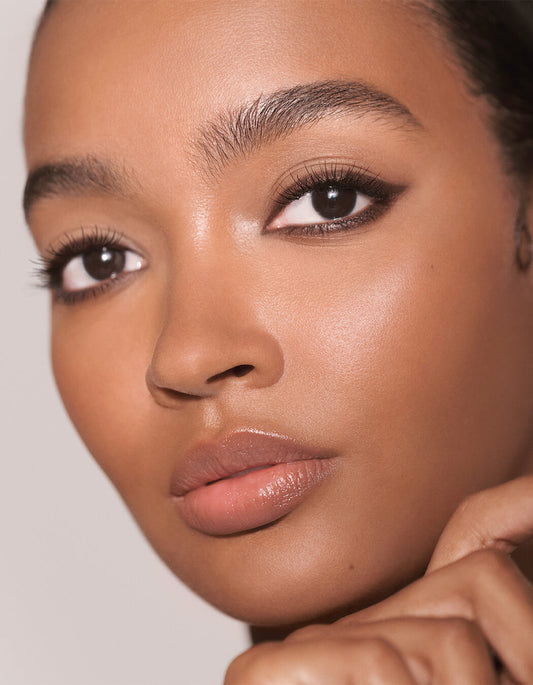 Nahaufnahme einer Frau mit glatter, strahlender Haut und natürlichem Make-up, wobei Augen durch den RevitaLash® Cosmetics Defining Liner Eyeliner betont sind.