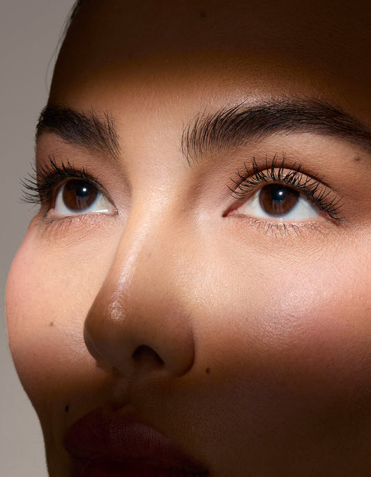 Nahaufnahme eines Gesichts mit Fokus auf Augen und Brauen – volle, definierte Wimpern und gepflegte Augenbrauen im natürlichen Licht.