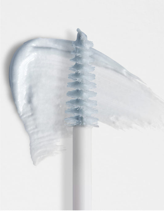 Eine Nahaufnahme des RevitaLash® Cosmetics Lash & Brow Masque-Bürstchens mit weißer Formel auf weißem Hintergrund.