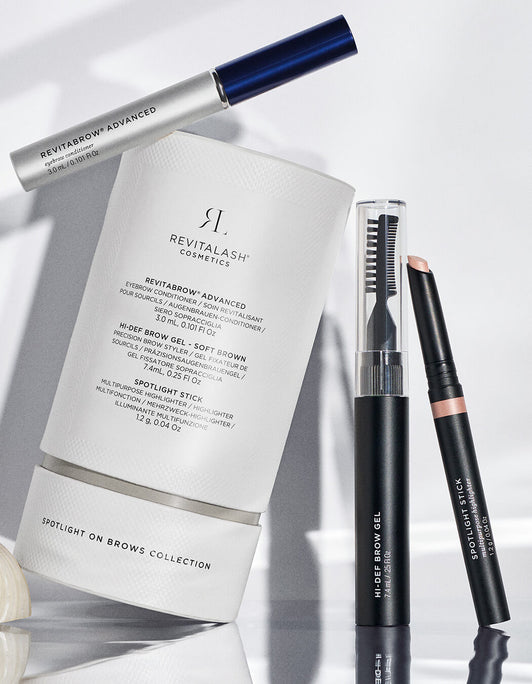 Spotlight on Brows RevitaBrow® Advanced Spring Collection 2026 von RevitaLash® Cosmetics zeichnet sich durch eine elegante weiße Verpackung und schwarze Brauenstifte aus, die auf einer hellen Oberfläche wunderschön präsentiert werden.