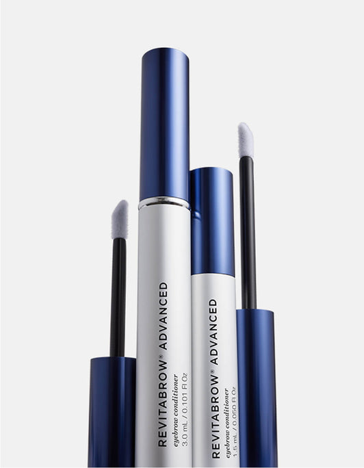 Zwei silberne Tuben RevitaLash® Cosmetics RevitaBrow® Advanced Eyebrow Conditioner mit blauen Kappen, zwei weitere blaue Applikatorstäbe daneben, vor weißem Hintergrund.