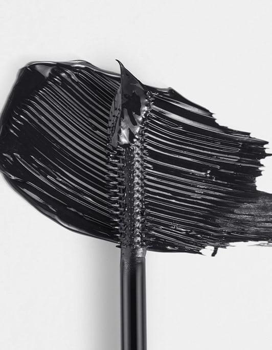 Nahaufnahme der RevitaLash® Cosmetics Length Define Tubing Mascara-Bürste mit verschmierter schwarzer Wimperntusche auf weißem Hintergrund.