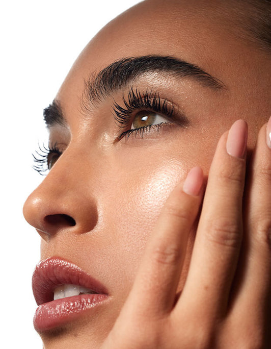 Nahaufnahme des Gesichts einer Frau mit strahlender Haut, langen Wimpern und gepflegten Augenbrauen- dank der Strength & Define Collection – RevitaBrow® Advanced von RevitaLash® Cosmetics.