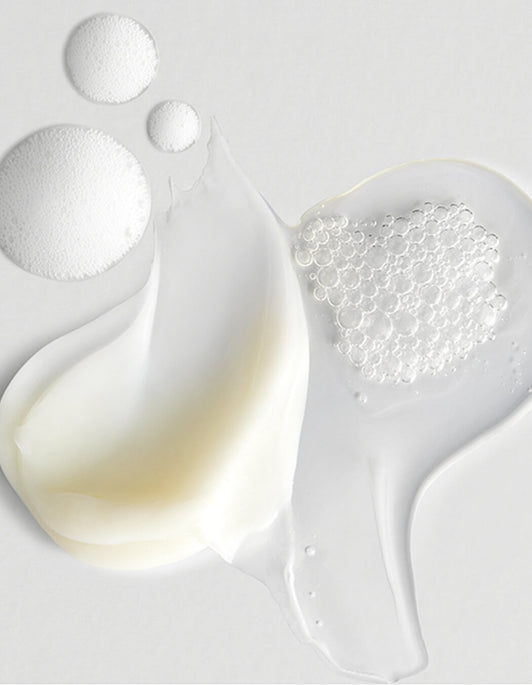 RevitaLash® Cosmetics Volume Enhancing Foam-Texturen: schaumige Bläschen auf klarem Gel auf weißem Hintergrund.