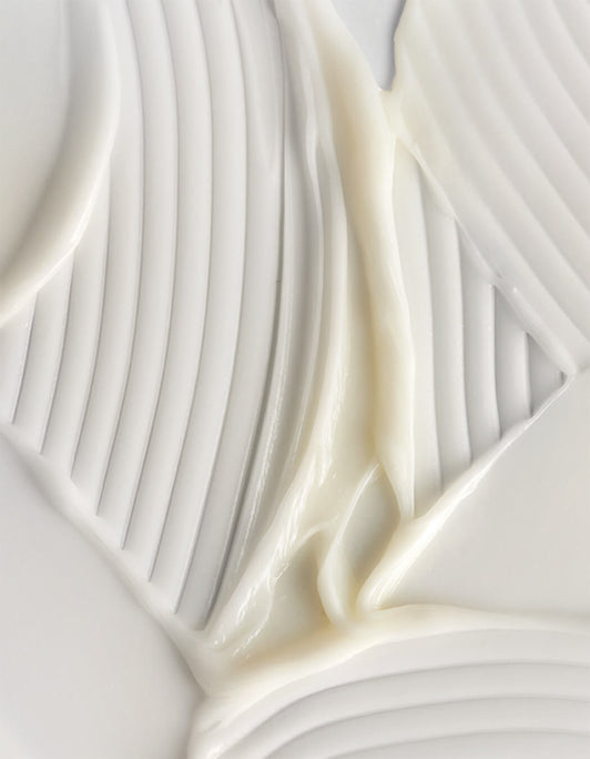 Cremeweiße glatte Textur des RevitaLash® Cosmetics Thickening Conditioner mit strukturierten Linien und weichen, glänzenden Wirbeln.
