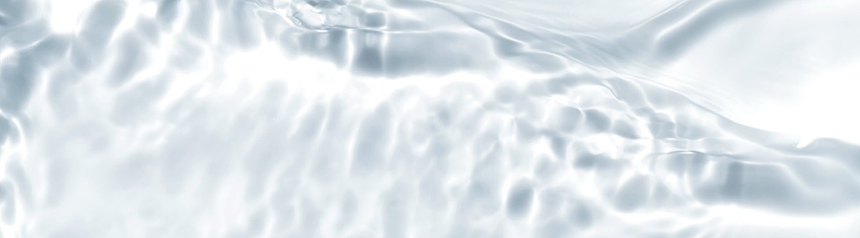 Gewellte Lichtmuster spiegeln sich auf einer klaren Wasseroberfläche.