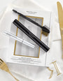 RevitaLash Geschenkset mit Mascara, Conditioner und Styling-Tool, elegant präsentiert auf weißem Stoff mit goldenen Besteckdetails.